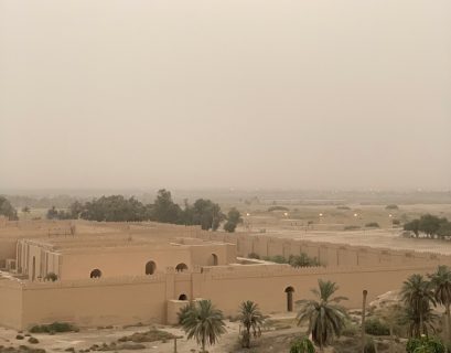 Korkealta otetussa kuvassa näkyy alhaalla suuri muinaistyylinen palatsi ja palmuja aavikkomaisessa maisemassa.