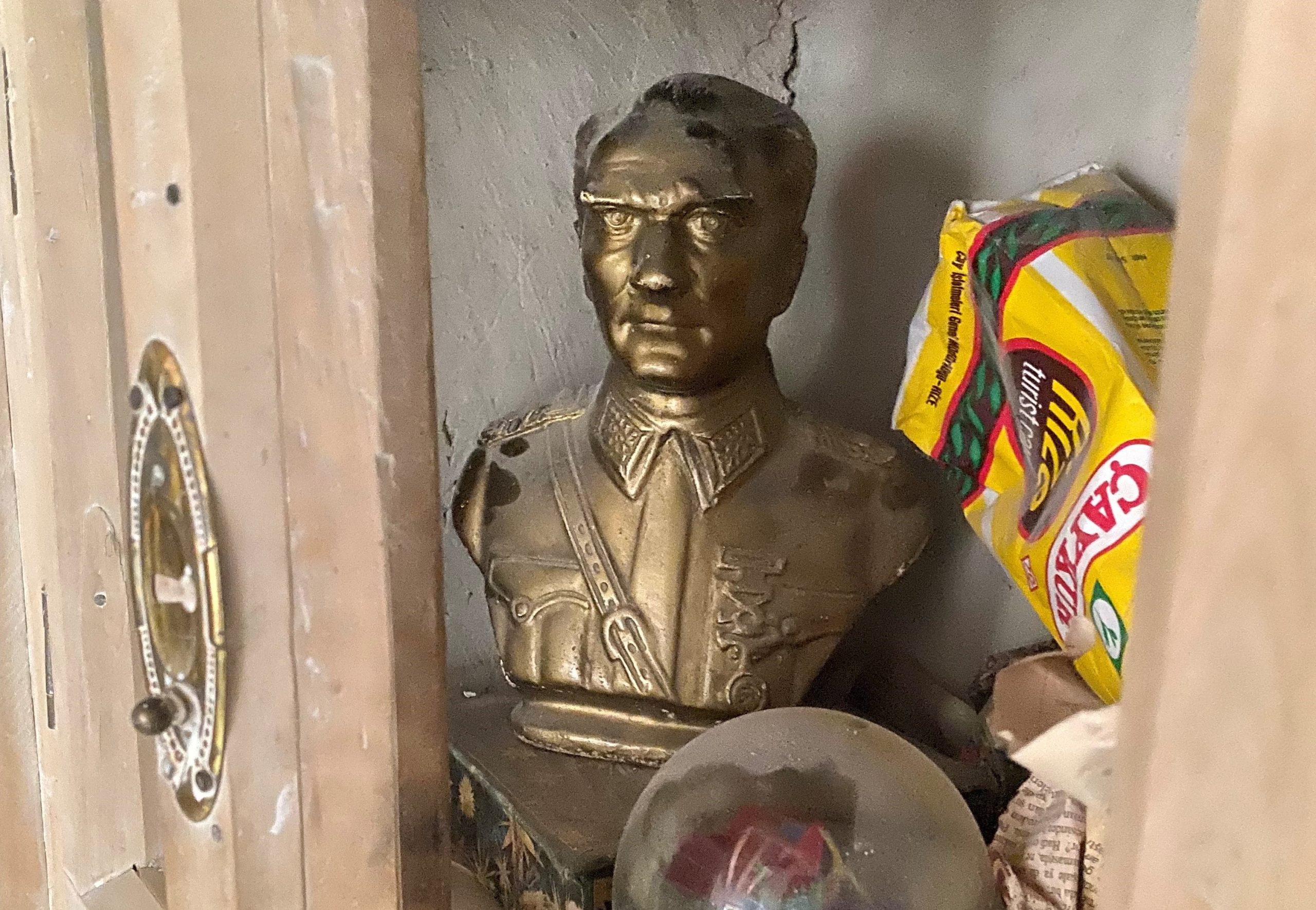 Pölyinen Atatürkin rintakuva kaapissa kaikenlaisen roinan keskellä