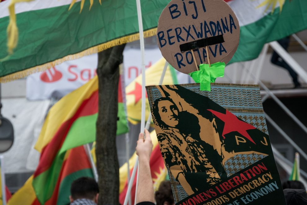 Mielenosoitus, jossa vastustetaan Turkin aggressioita Syyrian kurdeja kohtaan, Berliinissä 2019. Kuvassa Kurdistanin ja YPG:n liput sekä kyltti naisten ja Rojavasta vapautuksen puolesta. Kuva: TommoT.